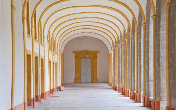 Abbaye de Cluny corridor with arched ceiling and stone columns, France.