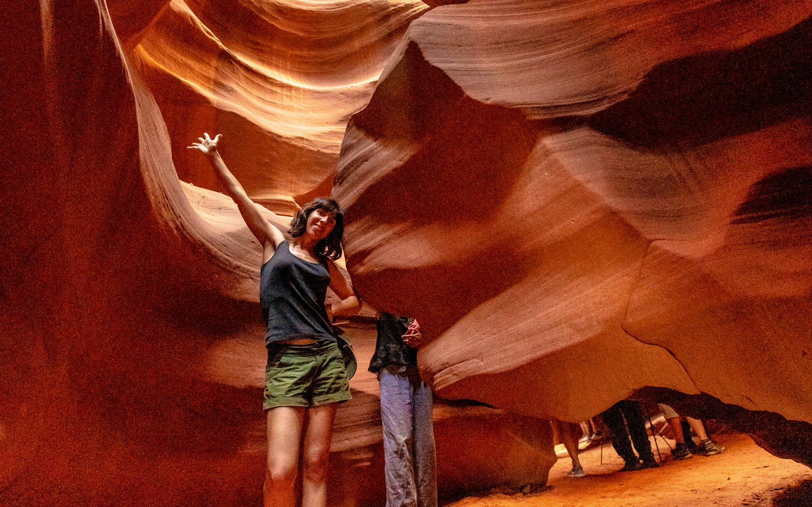 Young woman exploring Upper Antelope Canyon's sandstone formations.