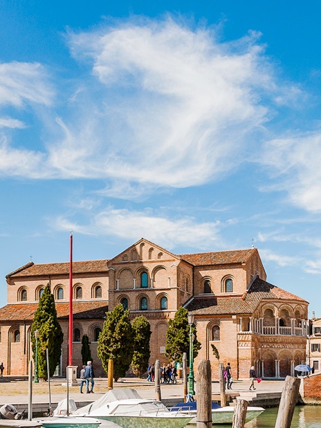 Santi Maria e Donato Basilica with bell tower in Murano, Italy, viewed from canal.