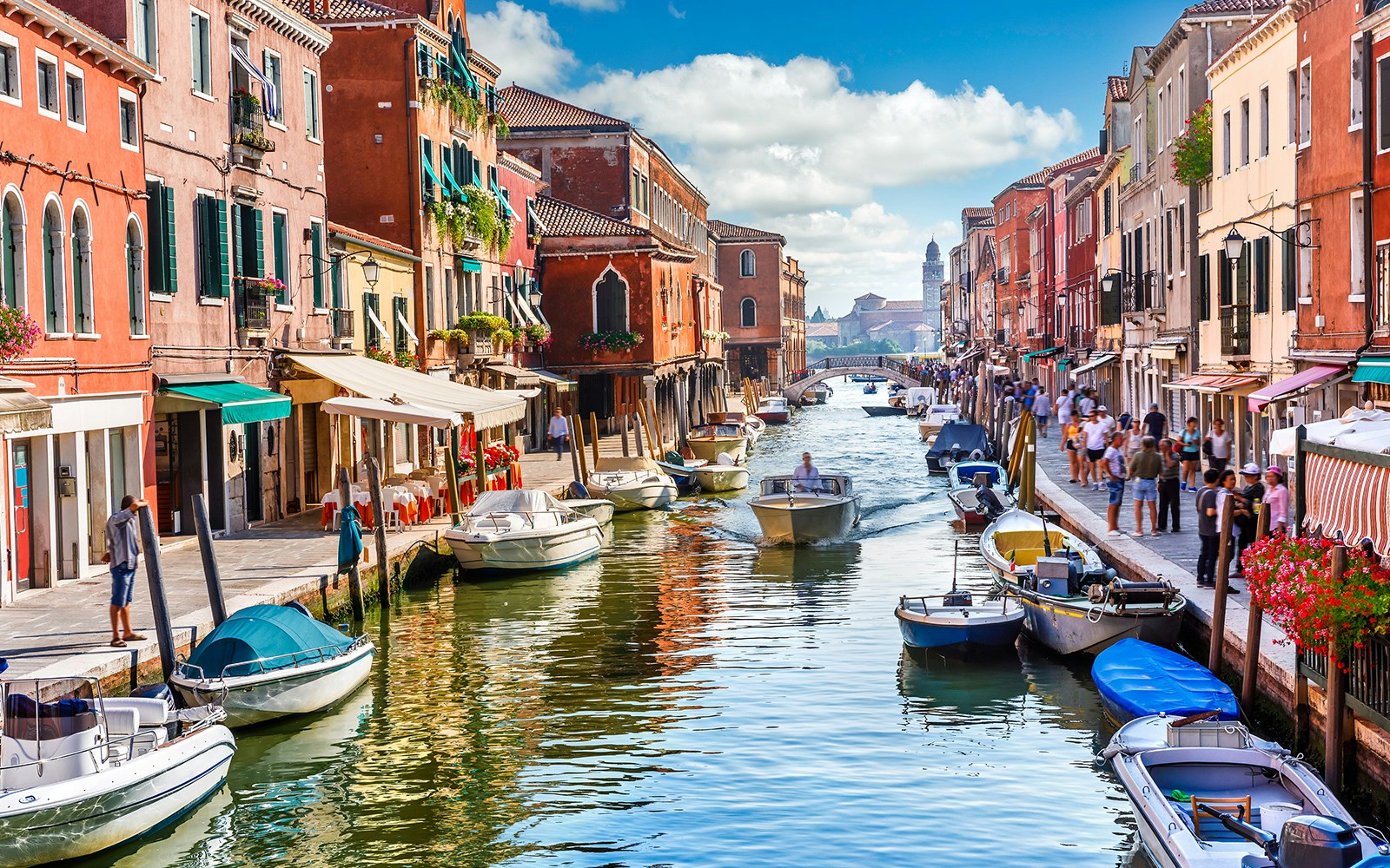 Murano Island canal with colorful buildings and boats, Venice full-day guided tour.