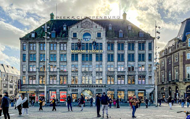 Madame Tussauds Amsterdam building exterior with people in Dam Square.