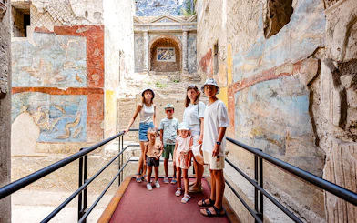 Group exploring ancient frescoes in Pompeii on a day trip from Rome.