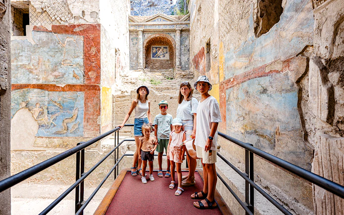 Group exploring ancient frescoes in Pompeii on a day trip from Rome.