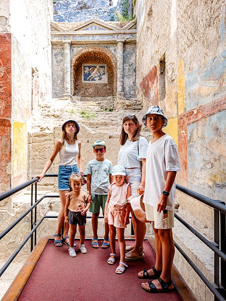 Group exploring ancient frescoes in Pompeii on a day trip from Rome.