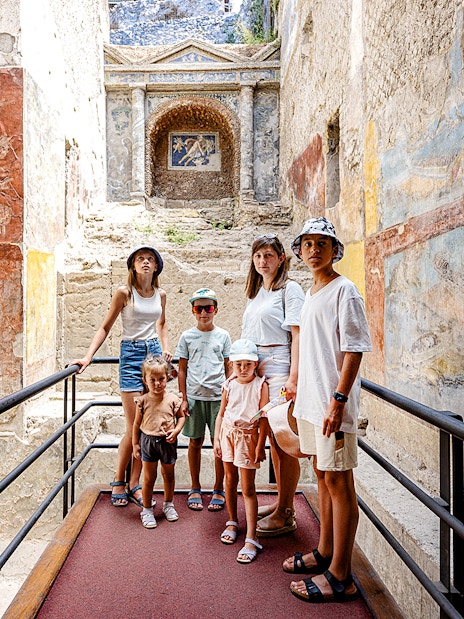 Group exploring ancient frescoes in Pompeii on a day trip from Rome.