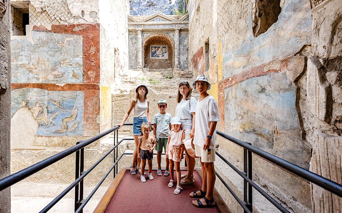 Group exploring ancient frescoes in Pompeii on a day trip from Rome.