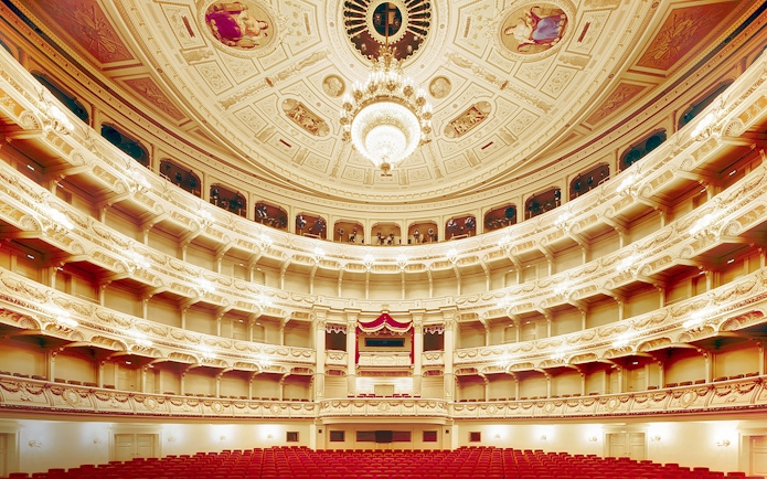 Semperoper Dresden auditorium with ornate ceiling and red seating.