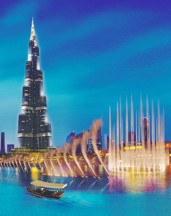 Burj Khalifa and Dubai Fountain with boat on water, Dubai, UAE.