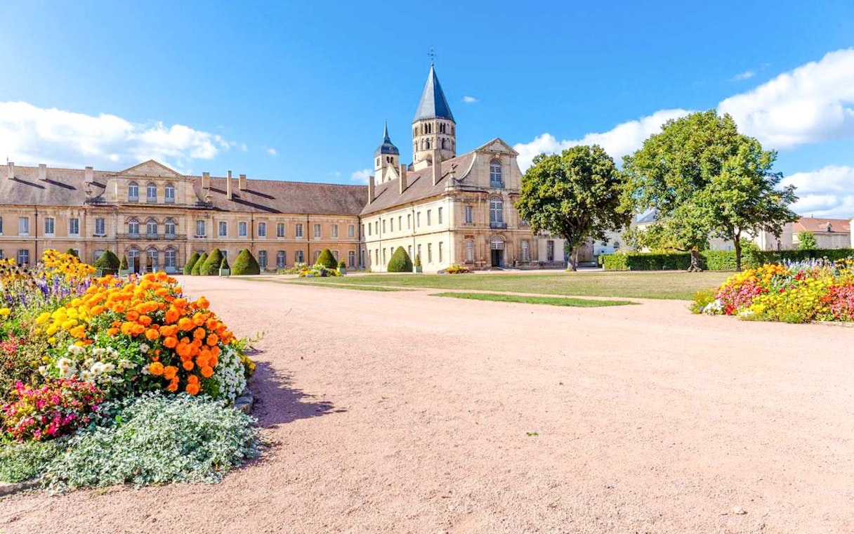 Cluny Abbey courtyard with colorful flowers, Lyon, France.