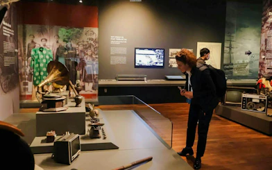 Tourists examining historical artifacts at Da Nang Museum exhibit on local culture and history.