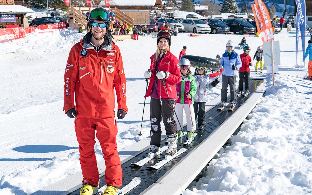 Beginner skiers on a conveyor lift in Grindelwald during a full-day ski package from Interlaken.