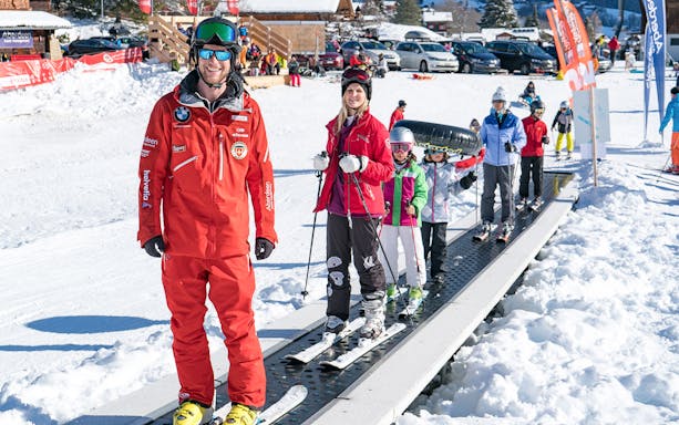 Beginner skiers on a conveyor lift in Grindelwald during a full-day ski package from Interlaken.