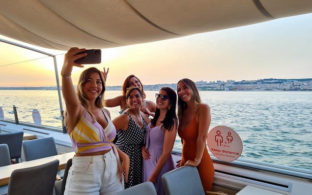 Group enjoying a sunset cruise on the Tagus River in Lisbon.