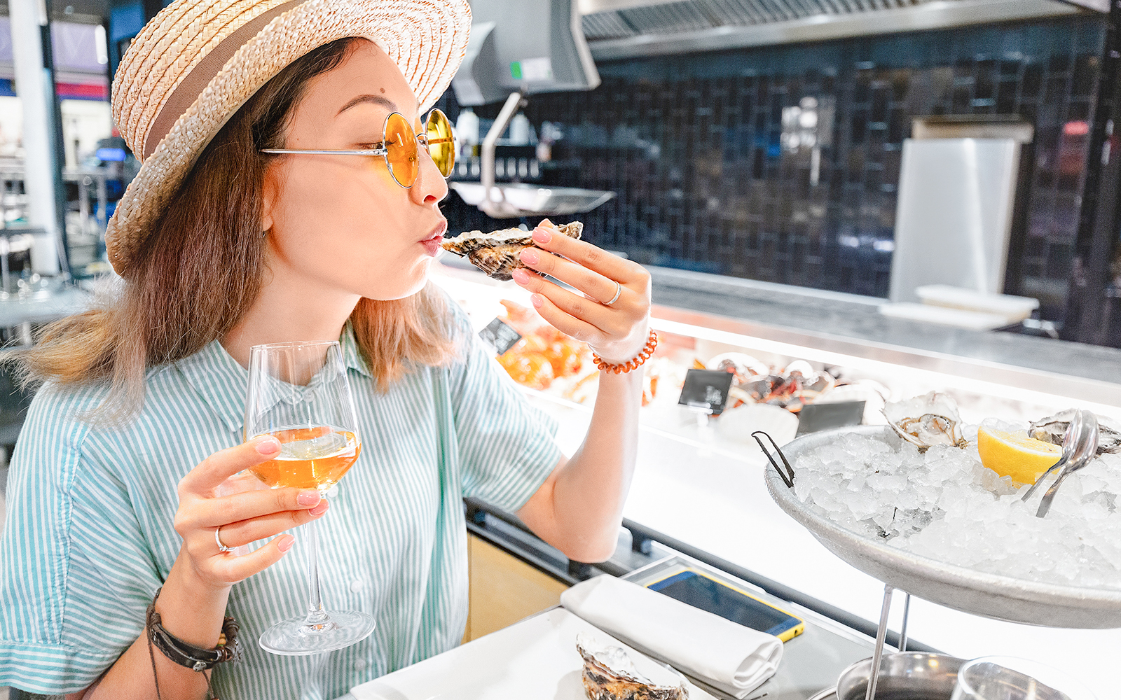 Seafood tasting at Mont Saint Michel with woman enjoying oysters and wine.