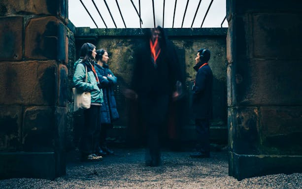Guests on the Doomed, Dead and Buried tour in Edinburgh standing in a historic stone structure.