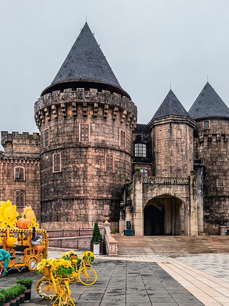 Central square in Ba Na Hills with castle towers and sunflower-themed decorations.