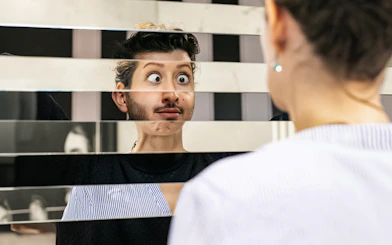Person looking into a fragmented mirror at Illuseum Berlin.