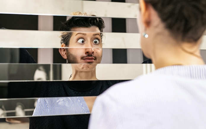 Person looking into a fragmented mirror at Illuseum Berlin.