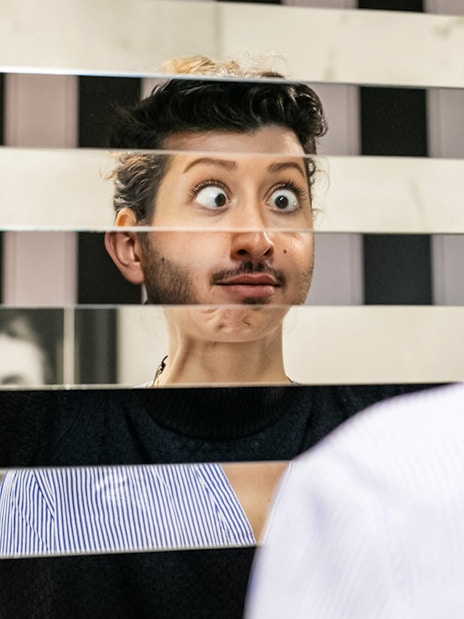 Person looking into a fragmented mirror at Illuseum Berlin.