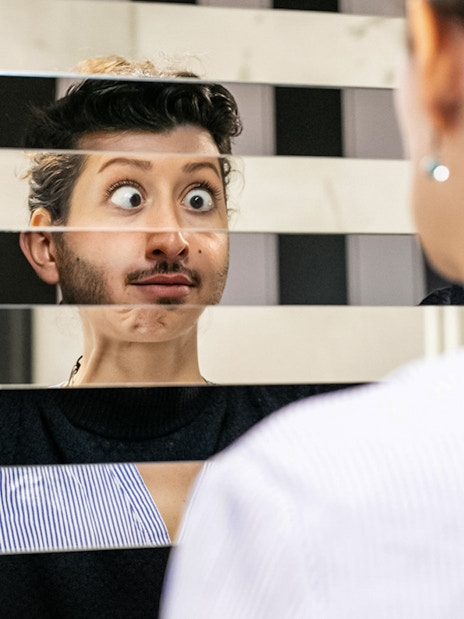 Person looking into a fragmented mirror at Illuseum Berlin.
