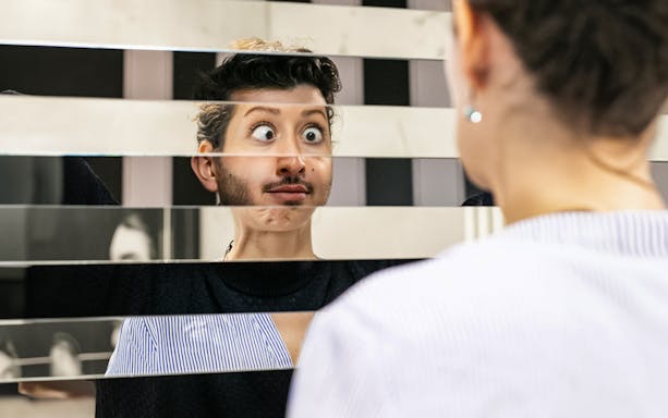 Person looking into a fragmented mirror at Illuseum Berlin.
