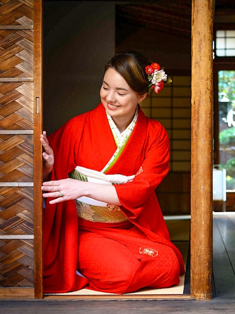 Person in kimono kneeling in traditional Kyoto machiya, preparing for tea ceremony.