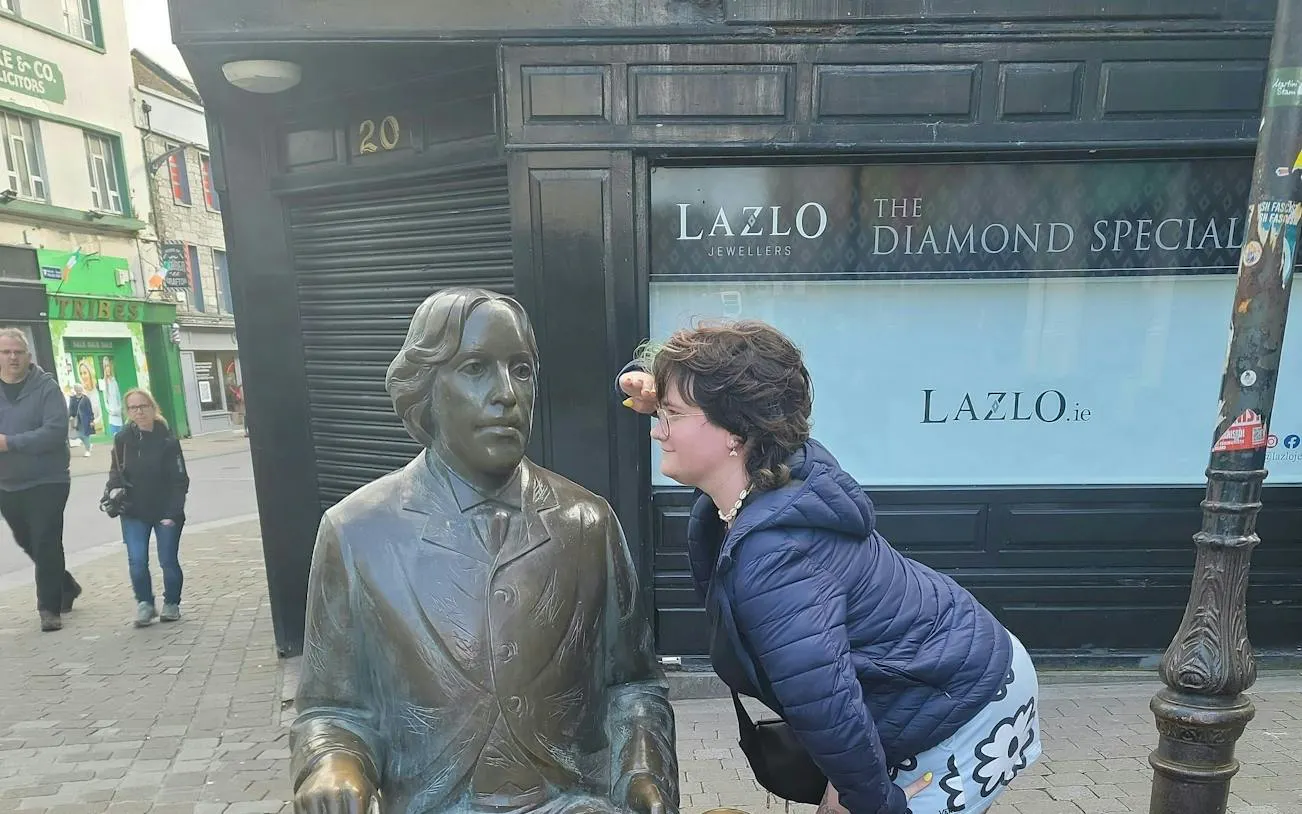 Person interacting with a statue on a Galway street during a self-guided city exploration game.