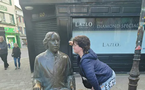 Person interacting with a statue on a Galway street during a self-guided city exploration game.