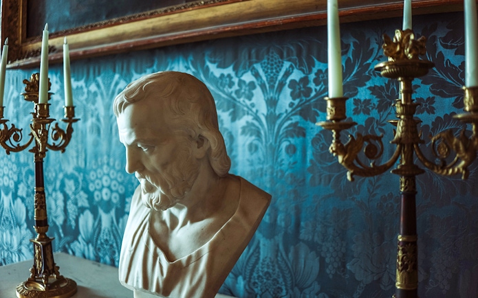 Bust sculpture and ornate candelabras in the Royal Palace of Caserta.