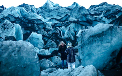 Guests exploring Solheimajokull glacier with icy formations in Iceland.