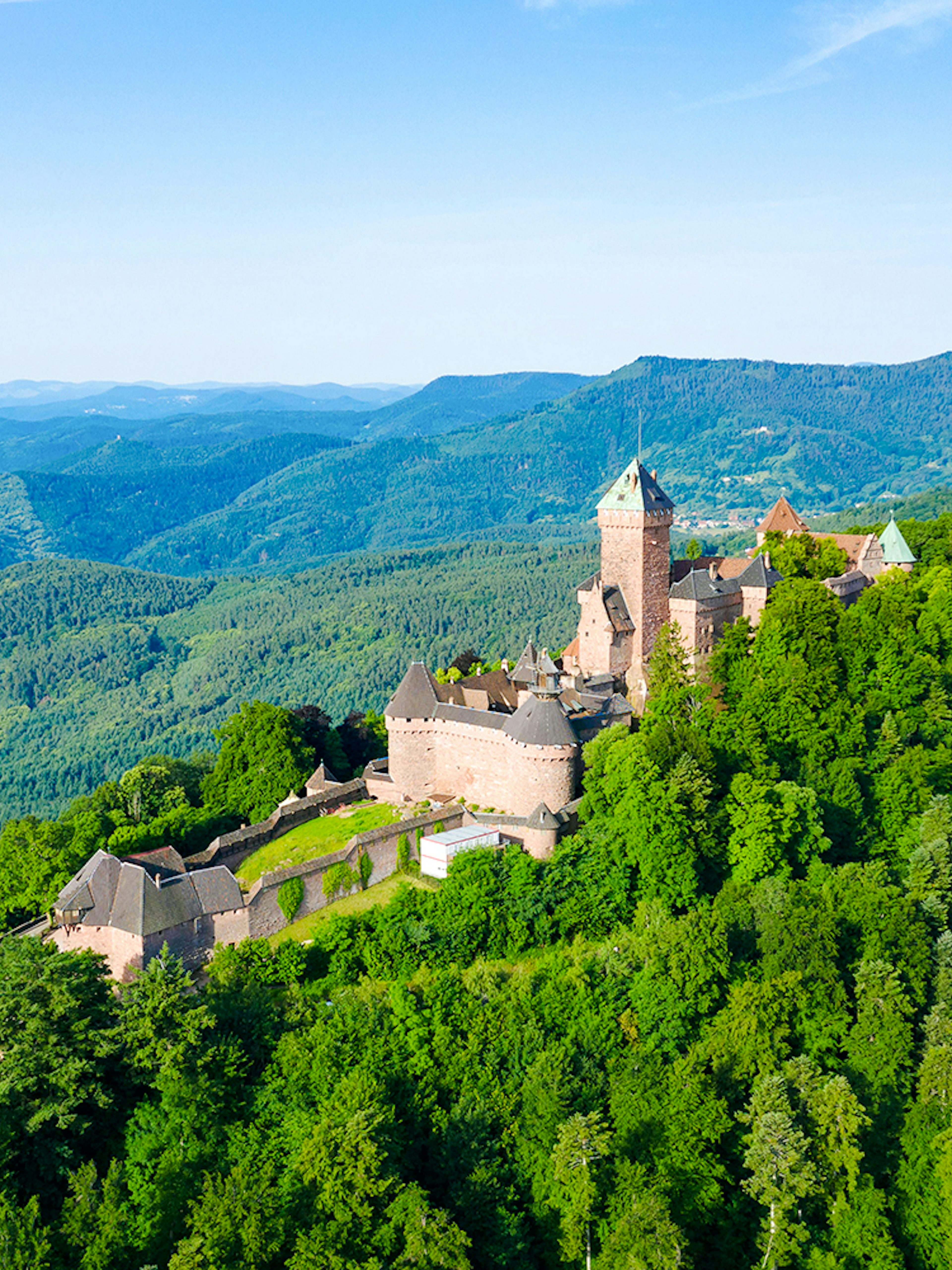 Medieval Haut Koenigsbourg Castle surrounded by lush forest in Alsace, France.