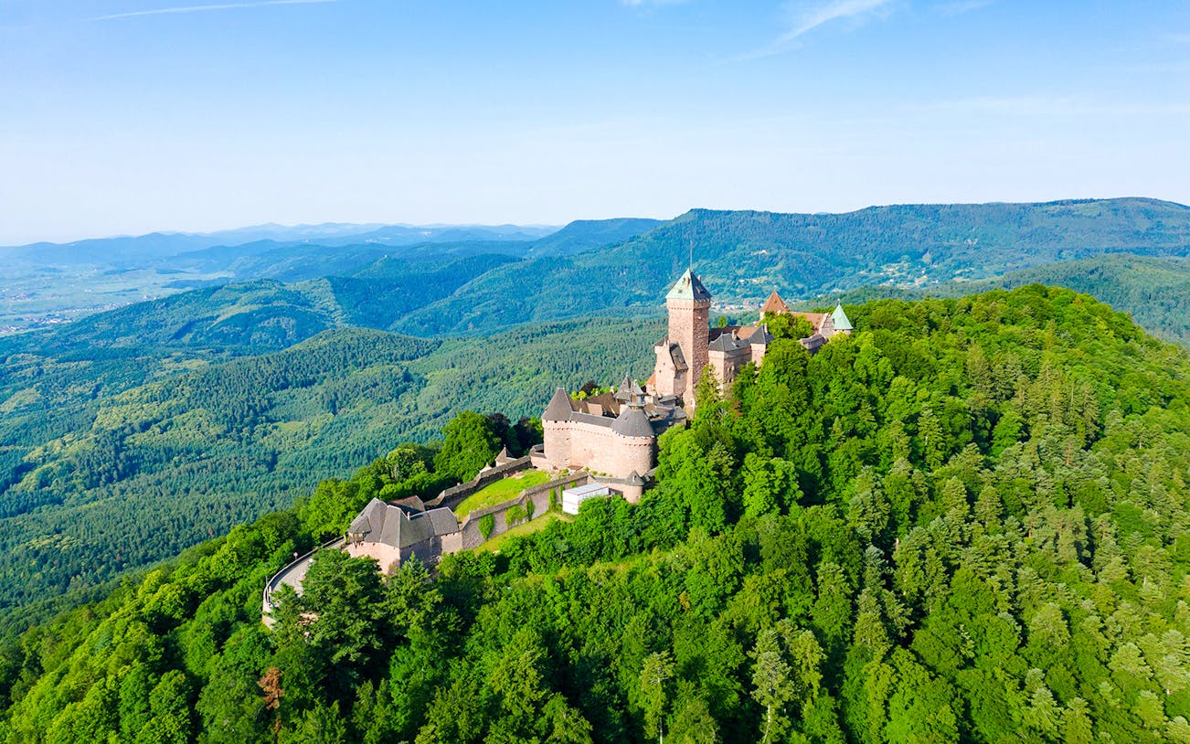 Medieval Haut Koenigsbourg Castle surrounded by lush forest in Alsace, France.