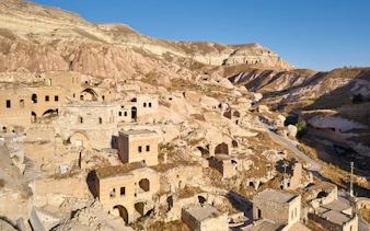 Cavusin old town with rock-cut dwellings and ancient structures in Cappadocia, Turkey.