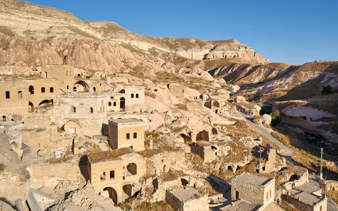 Cavusin old town with rock-cut dwellings and ancient structures in Cappadocia, Turkey.