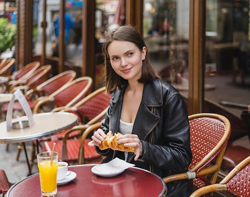 woman having croissant during notre dame street food tour