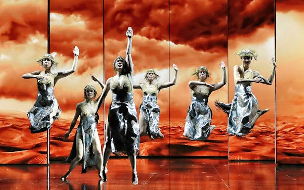 Performers in silver costumes dancing in Aida at Queensland Performing Arts Centre.