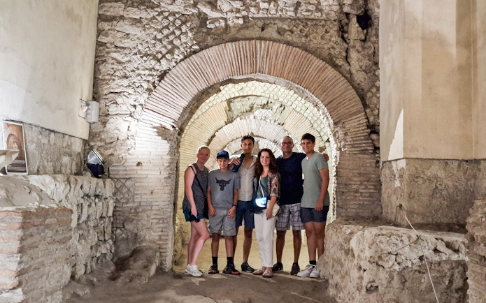 Tourists exploring Napoli Sotterranea underground ruins in Naples.