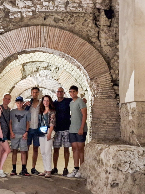 Tourists exploring Napoli Sotterranea underground ruins in Naples.