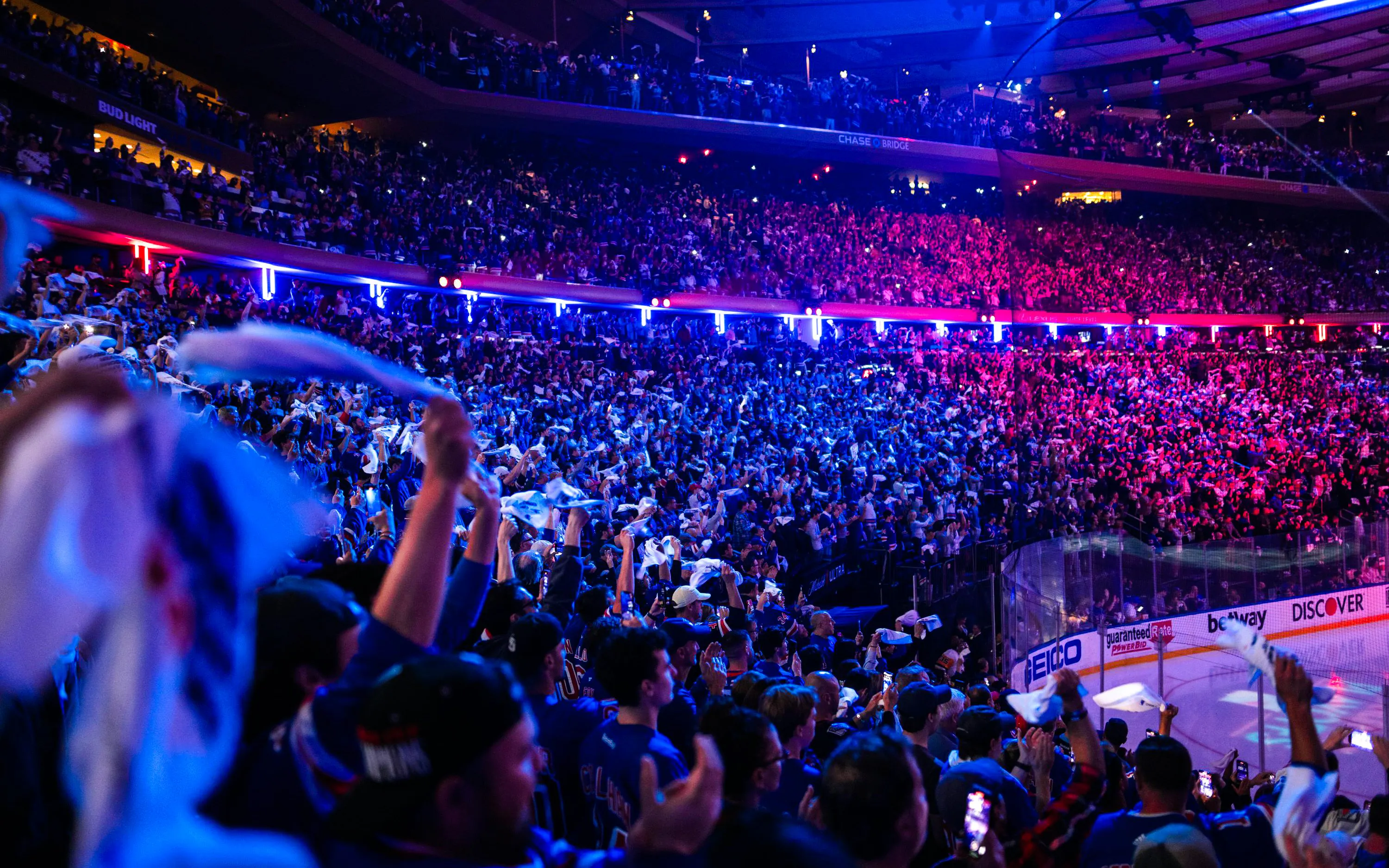 Crowd cheering at a New York Rangers game in Madison Square Garden.