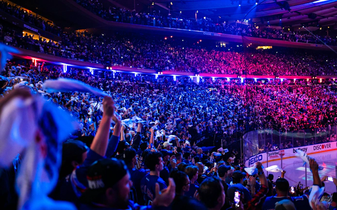 Crowd cheering at a New York Rangers game in Madison Square Garden.