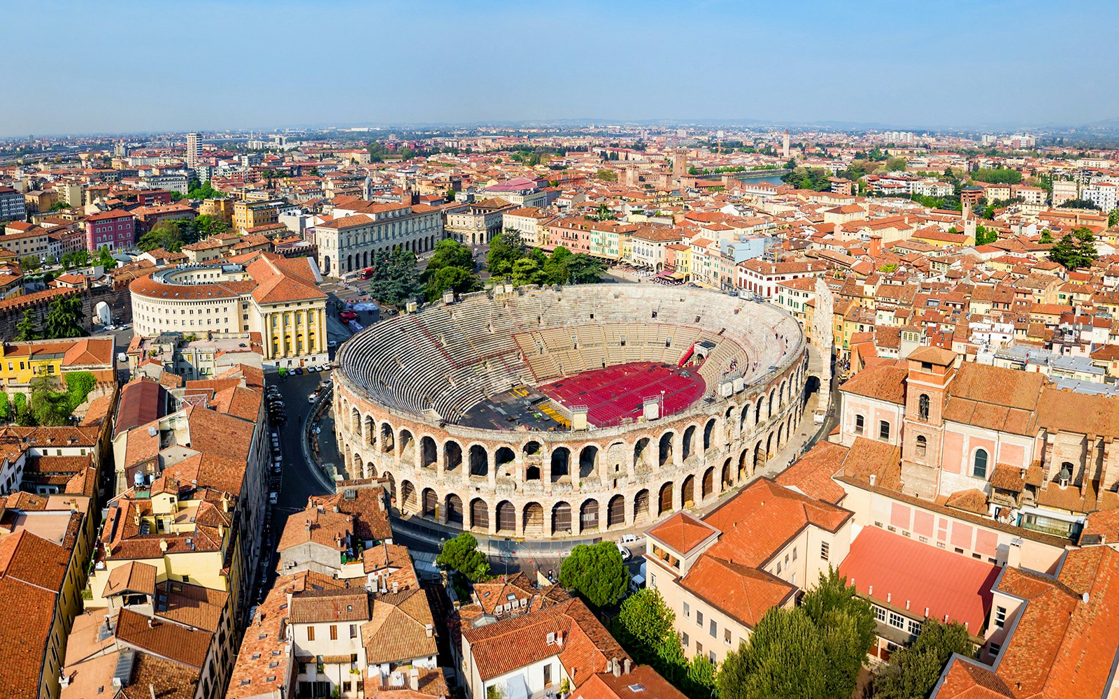 Aerial view of the Verona Arena surrounded by historic buildings in Verona, Italy.