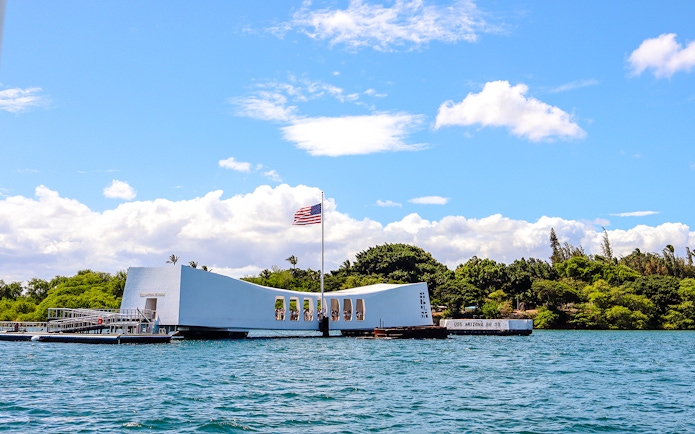 USS Arizona Memorial in Pearl Harbor, Hawaii, with American flag flying.