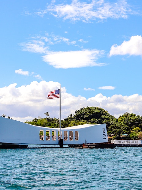 USS Arizona Memorial in Pearl Harbor, Hawaii, with American flag flying.