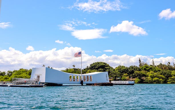 USS Arizona Memorial in Pearl Harbor, Hawaii, with American flag flying.