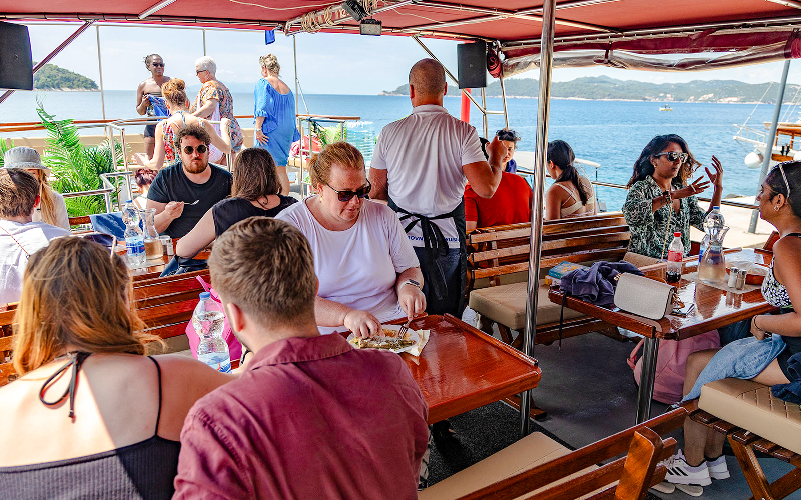 Guests dining on deck during Elaphite Island Cruise, Dubrovnik.