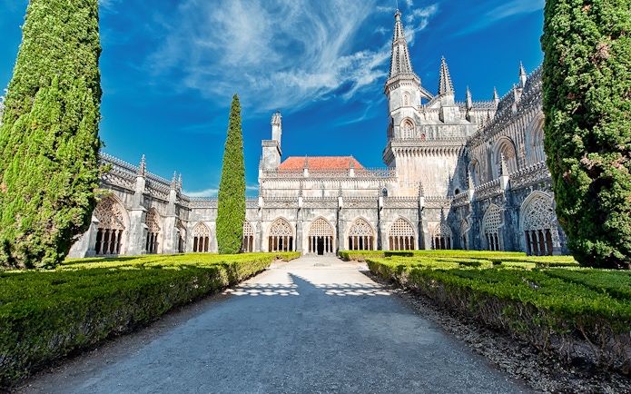 Abbey of Batalha Monastery with Gothic architecture and manicured gardens in Portugal.