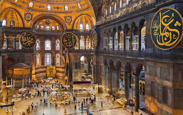 Hagia Sophia interior with ornate chandeliers and Arabic calligraphy, Istanbul.