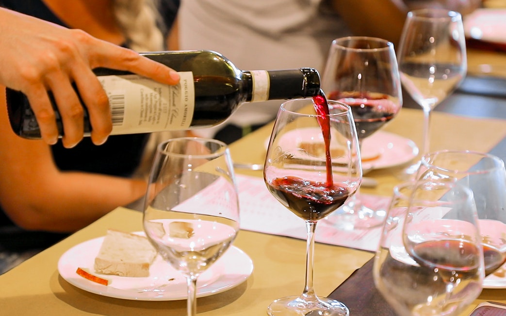 Wine being poured into a glass during a Chianti tasting on a Florence day trip.