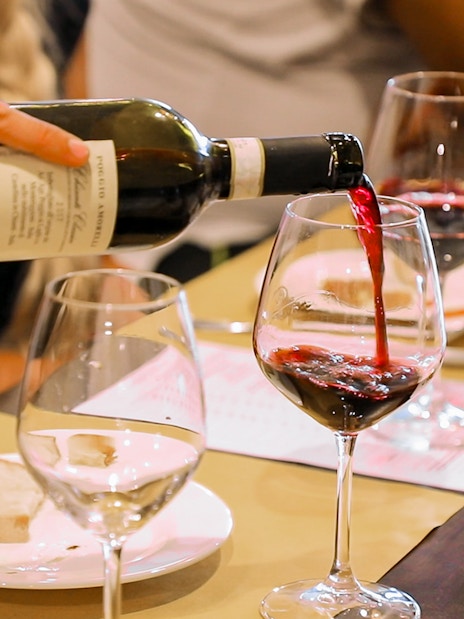Wine being poured into a glass during a Chianti tasting on a Florence day trip.