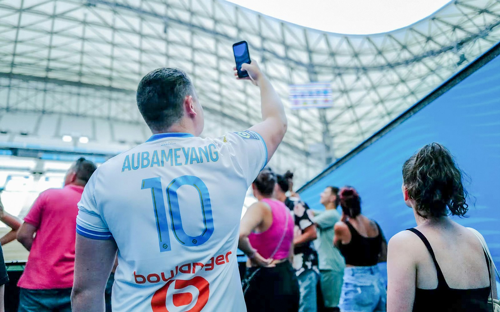 Visitors exploring the interior of a velodrome stadium during a tour.
